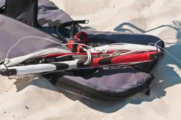 Top view of kiteboard handles and  cables  as well as the protective case in the sand of a tropical...