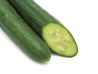 One whole and cut green cucumbers on white background