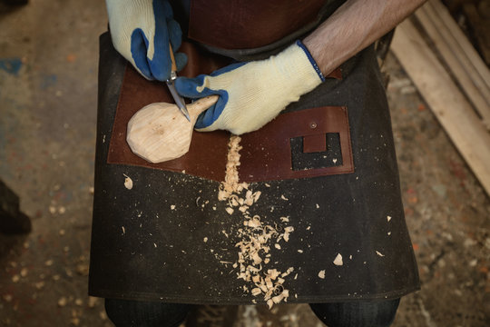 Mid section of carpenter making wooden spoon with worktool
