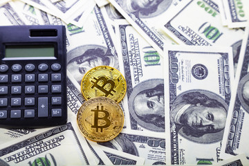 Fototapeta premium Calculator and bitcoins on dollars.