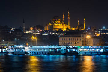 Night view at the Golden Horn Ferry Dock and Suleymaniye Mosque, Istanbul, Turkey.