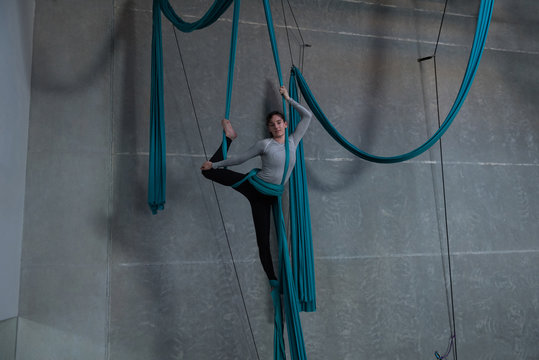 Gymnast exercising on blue fabric rope