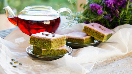 Matcha green tea cakes with white chocolate glaze seeds with tea on the white background