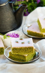 Matcha green tea cakes with white chocolate glaze seeds with tea on the white background