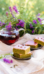 Matcha green tea cakes with white chocolate glaze seeds with tea on the white background