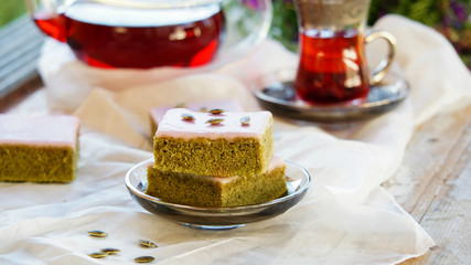 Matcha green tea cakes with white chocolate glaze seeds with tea on the white background