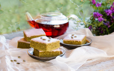 Matcha green tea cakes with white chocolate glaze seeds with tea on the white background