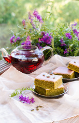 Matcha green tea cakes with white chocolate glaze seeds with tea on the white background