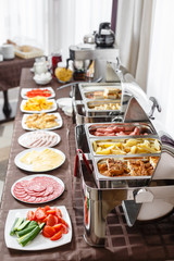 Buffet trays heated ready for service. Breakfast in hotel smorgasbord. Plates with different food