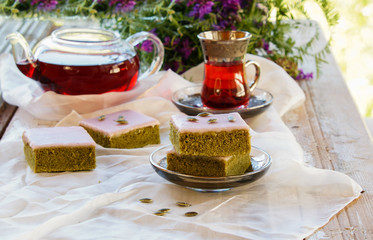 Matcha green tea cakes with white chocolate glaze seeds with tea on the white background