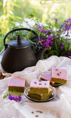 Obraz na płótnie Canvas Matcha green tea cakes with white chocolate glaze seeds with tea on the white background