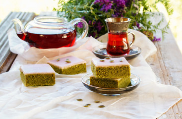 Matcha green tea cakes with white chocolate glaze seeds with tea on the white background