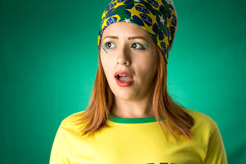 Brazilian woman fan celebrating on football match on green background.