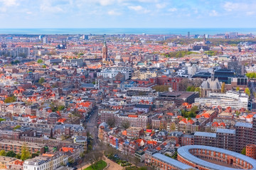 Aerial wide-angle cityscape of The Hague (Den Haag) with the North Sea and cloudy blue sky, Netherlands