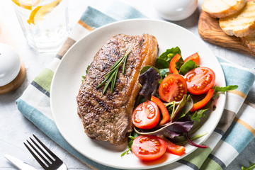 Grilled beef striploin steak with fresh salad.