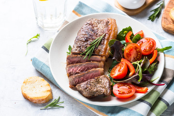 Grilled beef striploin steak with fresh salad.