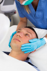 Obraz premium Woman doctor is massaging face of patient after the procedure