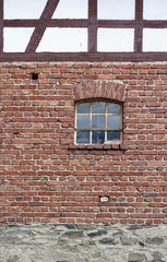 Vintage red brick wall with rusty window