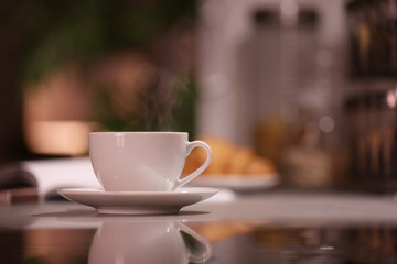 Fototapeta na wymiar Cup of hot coffee on blurred background