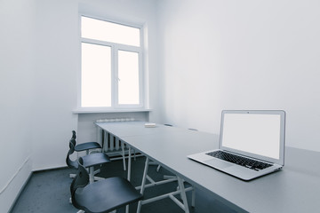 Interior of a stylish modern office. Workplace for a laptop in a light office. Room for negotiations in the office. The laptop is on the desk in the office