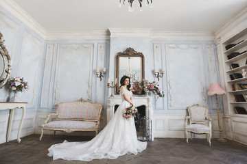 Beautiful bride, young model brunette woman, in stylish wedding dress with naked shoulders, with...
