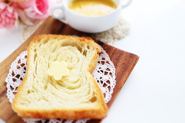 Pastry style sliced bread on wooden plate