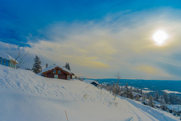 Outdoor beautiful landscape of wooden buildings with pine trees covered with snow in the forest...
