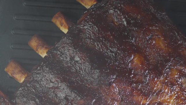 Closeup of roasting spare rib with bones on barbecue grill