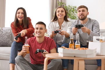 Obraz premium Młodzi ludzie grający w gry wideo w domu