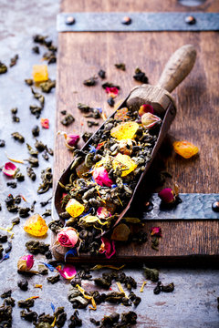 Dry Tea on the basis of Green with fruits and  rose petals, cornflower and calendula on a wooden background