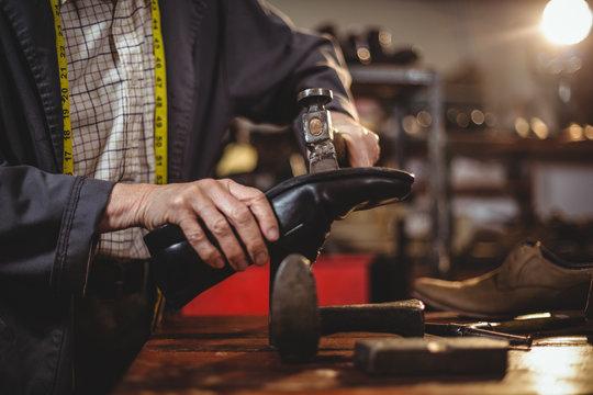 Shoemaker hammering on a shoe