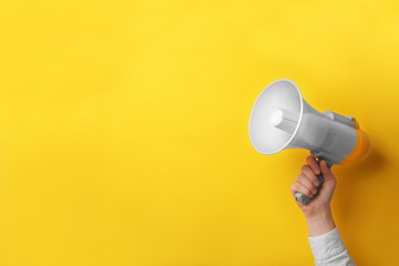 Man holding megaphone on color background