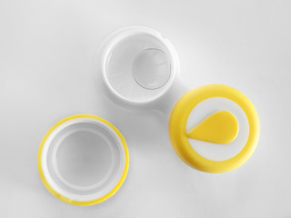 Container with contact lenses on white background