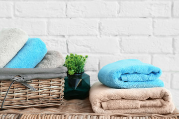 Fototapeta na wymiar Clean towels near brick wall in bathroom
