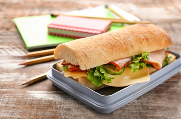Lunch box with tasty food on wooden background