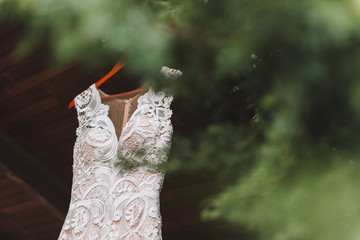 Sleeveless wedding dress with lots of details and embroidery hanging outside