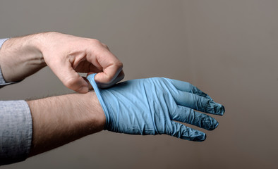 Fototapeta premium man putting on a pair of latex gloves
