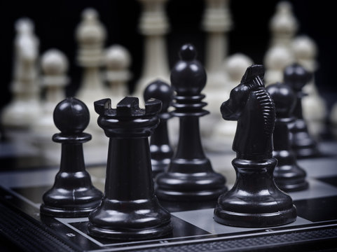 black chess pieces on white chess pieces background