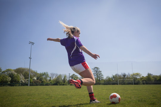 Full Length Of Woman Kicking Soccer Ball