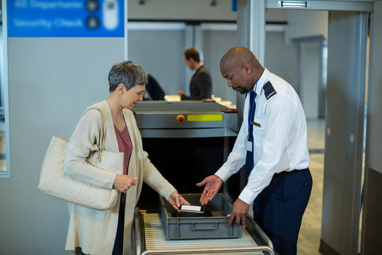 Airport security officer checking commuter mobile phone