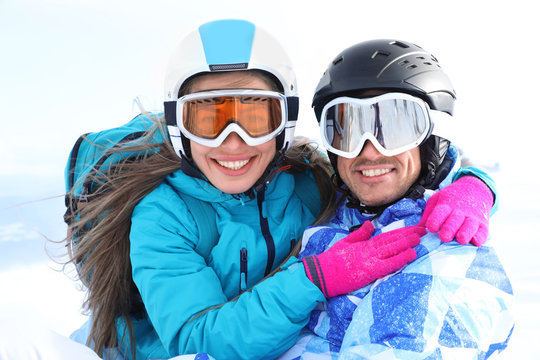 Happy couple at snowy ski resort. Winter vacation