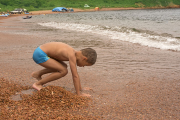 beautiful funny boy playing on the seashore