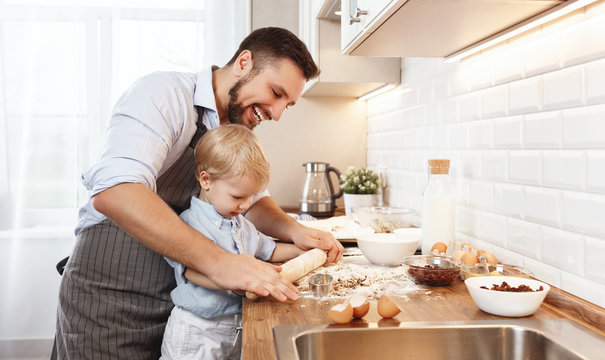 Happy Family In Kitchen. Father And Child Baking Cookies  .