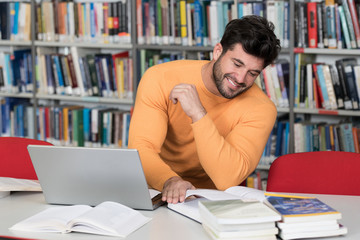 Happy Male Student With Laptop in Library