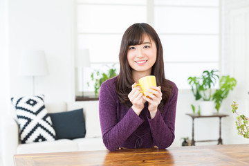 部屋で飲み物を飲む女性