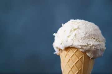 Vanilla ice cream in waffle cone, close up. Delicious refreshing summer seasonal snack for children