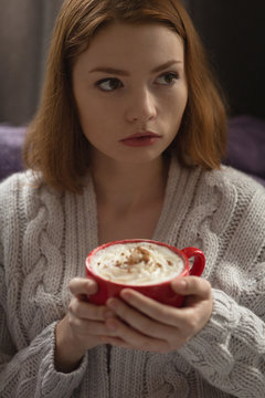 Close up of young woman holding cup of cappuccino
