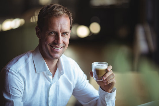 Portrait of smiling man holding cup of coffee