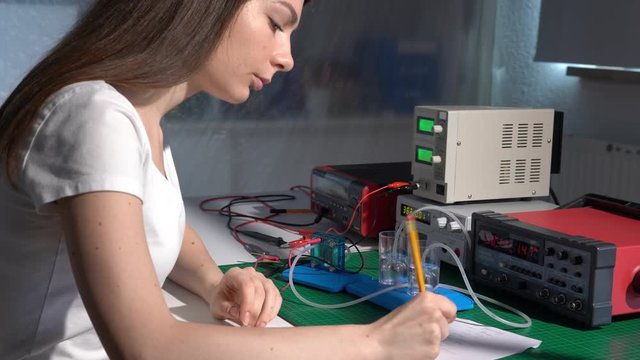 Young girl student in physical lab with hydrogen power cell