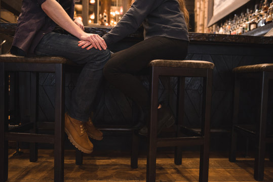Romantic couple sitting on stool at bar counter